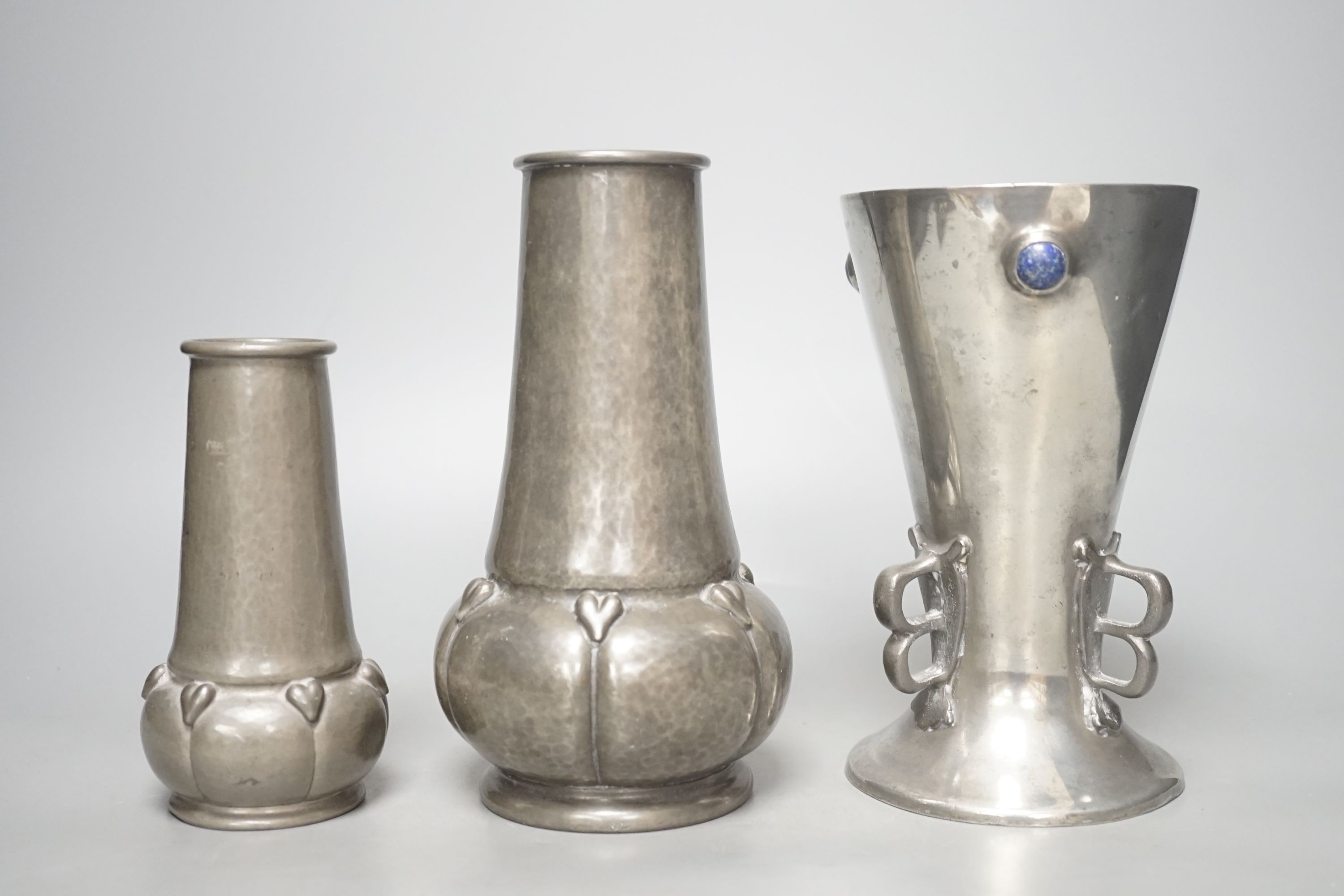 A Liberty & Co. lapis lazuli cabochon mounted Tudric pewter vase, stamped English pewter made by Liberty and Co. 038/4, 18 cm high and two other Tudric pewter vases, tallest 19cms high.